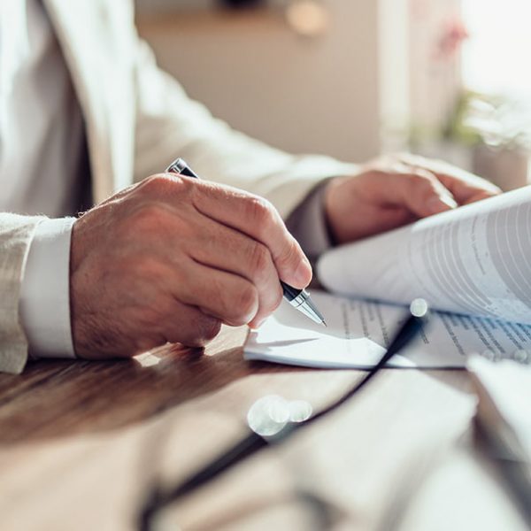 A person is writing on paper at the table.